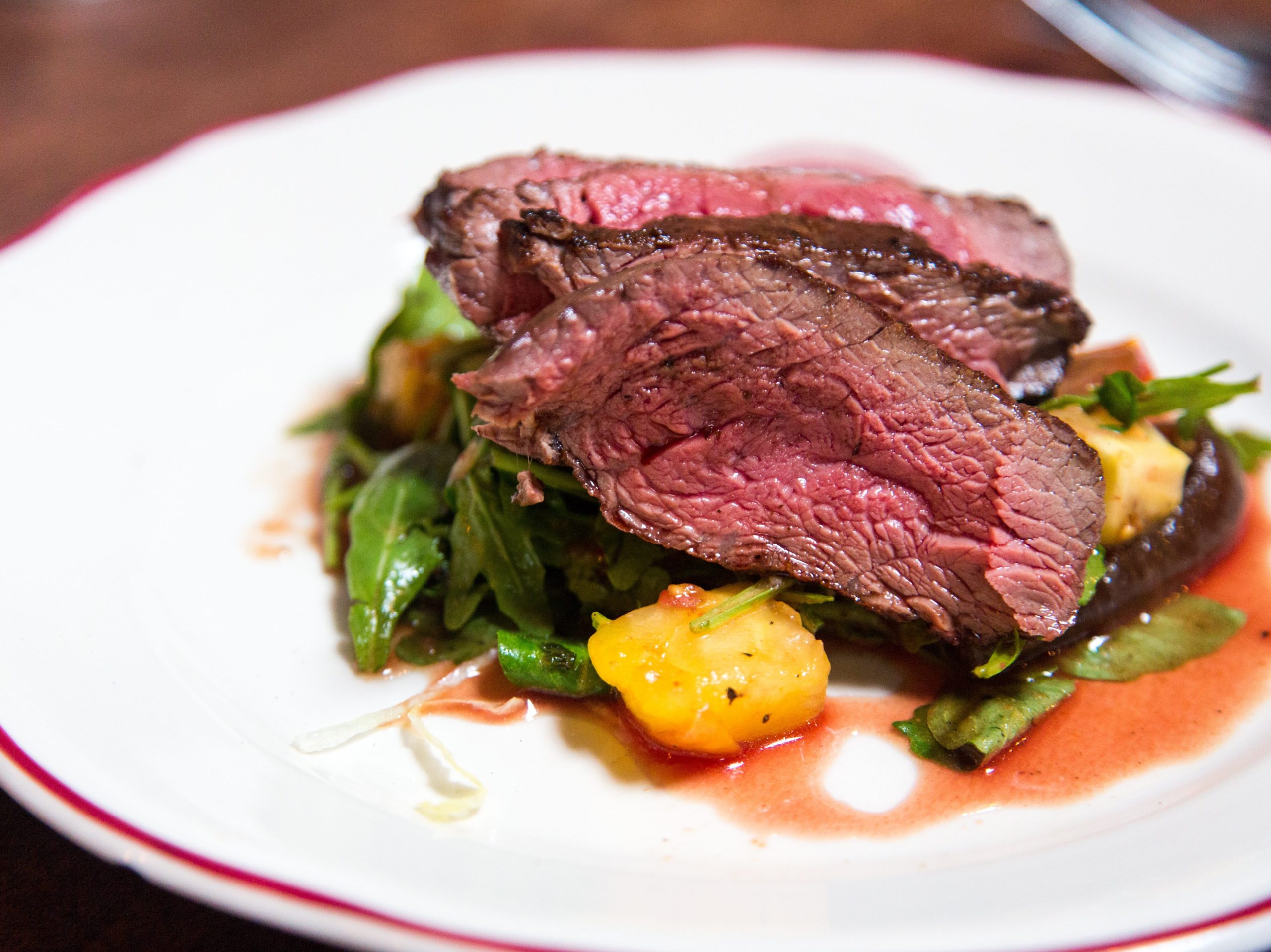 A cut of steak over some healthy veggies, making a complete, high-protein meal for any meat-eater.